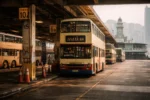Hong Kong bus terminus with buses arriving and passengers waiting in a busy urban setting