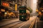Hong Kong double-decker tram moving through city streets with passengers on upper deck
