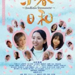 小春站在醫院長廊中，凝望窗外微弱陽光的沉靜畫面
